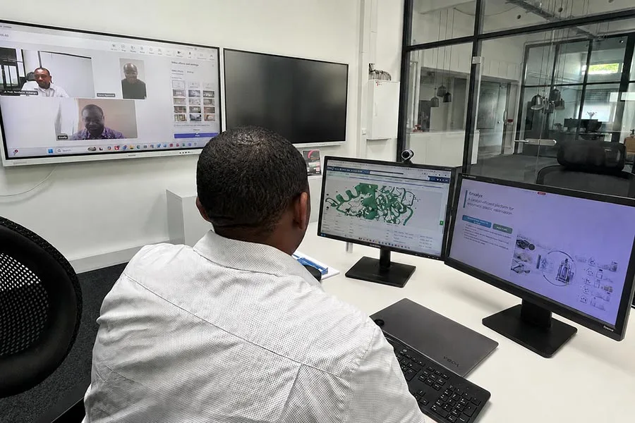 Envalyx workspace showing enzyme-structure analysis while co-founders Funso Ogunmolu, PhD, and Olakunle Kayode, PhD, join Peter Adeboye, PhD, remotely on screen